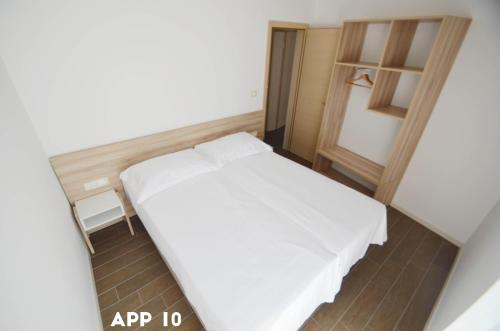 a small bedroom with a white bed in a room at Casa Maly in Portorož