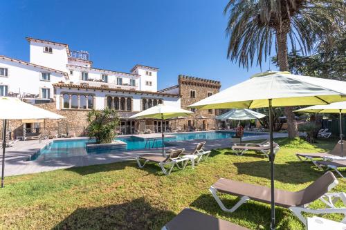 a resort with a pool with chairs and umbrellas at Hotel Castell Blanc in Empuriabrava