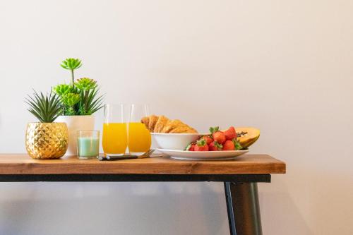 a table with a plate of fruit and a glass of orange juice at Marques studio in Porto da Cruz