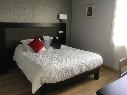 Ένα ή περισσότερα κρεβάτια σε δωμάτιο στο LOGIS HÔTEL RESTAURANT SPA Les BALCONS DE L'ESPERANCE