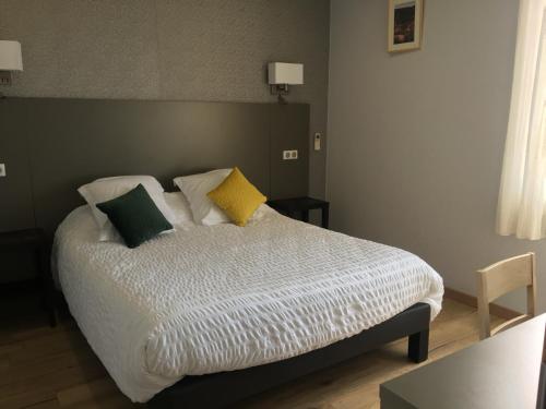 Ένα ή περισσότερα κρεβάτια σε δωμάτιο στο LOGIS HÔTEL RESTAURANT SPA Les BALCONS DE L'ESPERANCE