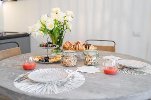 a table with plates and a vase of flowers and food at Nest House & Relax in Civitanova Marche