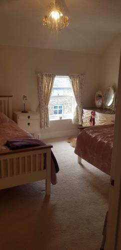a bedroom with a bed and a window at Lavender Cottage in Presteigne