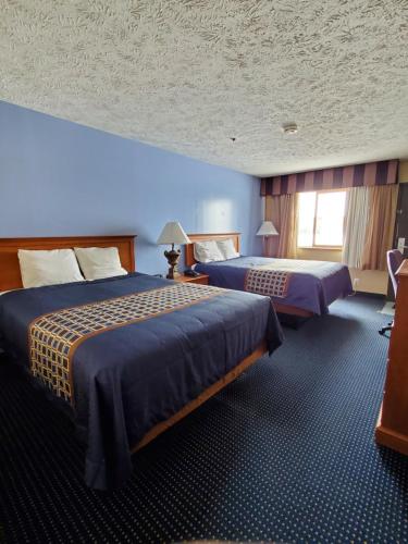Habitación de hotel con 2 camas y pared azul en VICTORIAN INN, en Central City