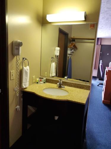 La salle de bains est pourvue d'un lavabo et d'un miroir. dans l'établissement VICTORIAN INN, à Central City