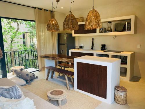 a living room with a table and a kitchen at Vida Boho Apart 10 with special fee to access Hotel Bardo in Tulum