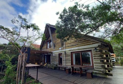 a log cabin with benches on a deck at Cabaña Navajuá in La Paloma