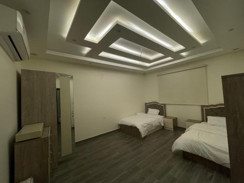 Luxury OVO Roof Villa في الطائف: غرفة بسريرين ومرآة