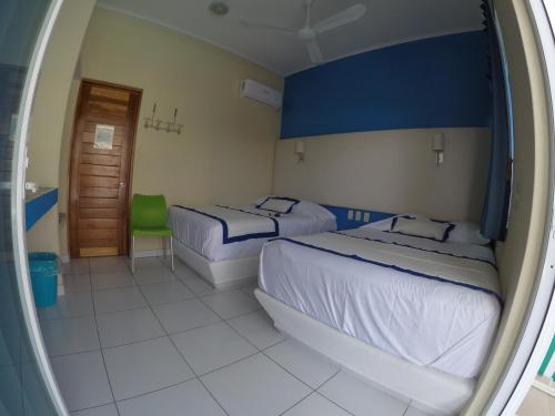 a hotel room with two beds and a window at Casa Mia in Puerto Escondido