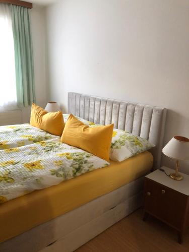 a bedroom with a bed with yellow pillows and a window at ALTSTADT-APARTMENTS Bad Radkersburg - Ihr Zuhause auf Reisen in Bad Radkersburg