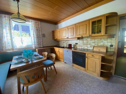 a kitchen with wooden cabinets and a table and chairs at ALTSTADT-APARTMENTS Bad Radkersburg - Ihr Zuhause auf Reisen in Bad Radkersburg