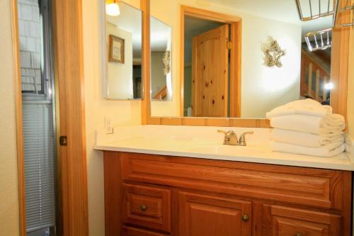 a bathroom with a sink and a mirror and towels at Sierra Park Villas #29 in Mammoth Lakes