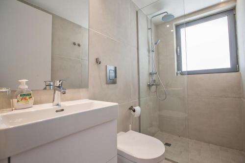 La salle de bains est pourvue d'un lavabo, de toilettes et d'une douche. dans l'établissement The White H Villa, Protaras, Fresh and Peaceful, à Paralímni