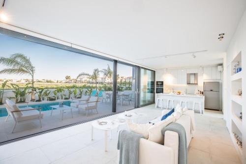 a living room with a view of a pool at The White H Villa, Protaras, Fresh and Peaceful in Paralimni
