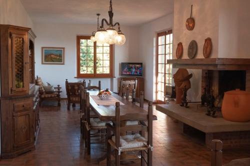 uma sala de jantar com uma mesa e uma lareira em Poggio Leporaia em Lamporecchio