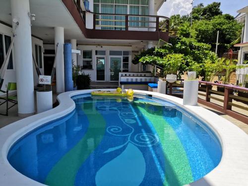 a swimming pool with a blue tub and a blue chair at Casa Mia in Puerto Escondido