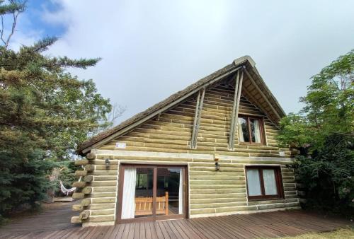a log cabin with a wooden deck at Cabaña Navajuá in La Paloma