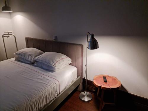 a bedroom with a bed with a lamp and a table at Rosa Biscoito Suites in Luso