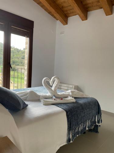 Un dormitorio con una cama con dos cisnes blancos. en CASA LA ABUELA en Olocau del Rey