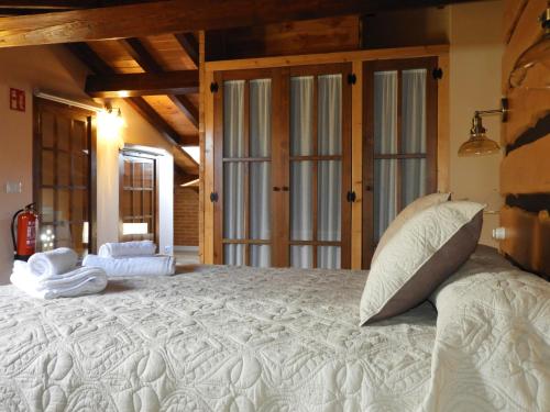 Elle comprend un grand lit avec des draps et des oreillers blancs. dans l'établissement Casa rural El Rincón de las Estrellas, à Sigüenza