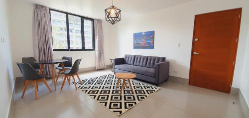 ein Wohnzimmer mit einem Sofa, einem Tisch und Stühlen in der Unterkunft Sori Apartments in Lima