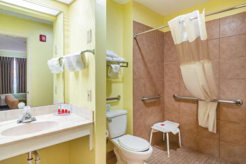 a bathroom with a toilet and a sink and a shower at SureStay Hotel by Best Western Brunswick in Brunswick