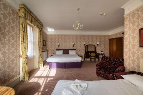 a bedroom with a bed and a couch and a chair at Hall Garth Hotel Darlington, Sure Hotel Collection by BW in Darlington
