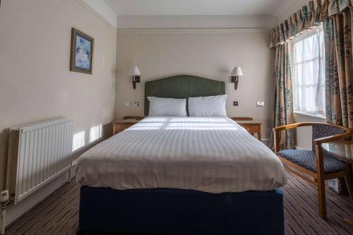 a bedroom with a large bed and a chair at Hall Garth Hotel Darlington, Sure Hotel Collection by BW in Darlington