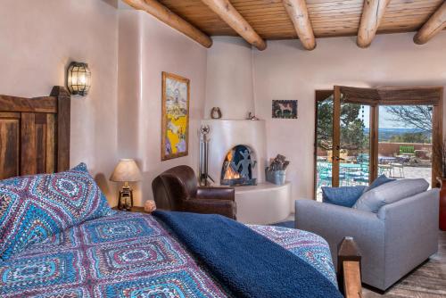 ein Schlafzimmer mit einem Bett, einem Sofa und einem Stuhl in der Unterkunft Bobcat Inn in Santa Fe
