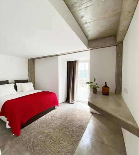 a bedroom with a bed with a red blanket at Fran Pacheco 39 (downtown apartment) in Setúbal