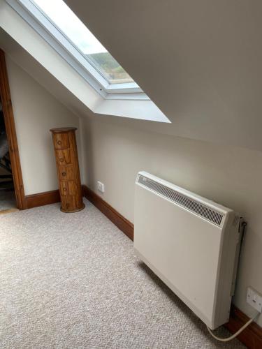 a room with a fan and a skylight at Mawenyoupe in Lochgilphead