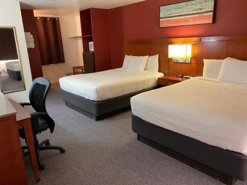 a hotel room with two beds and a desk at Lakeshore Inn Water Front in Moses Lake