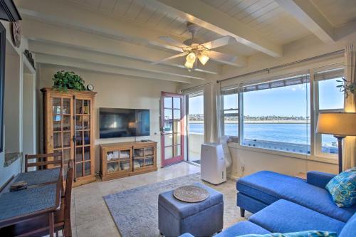 a living room with a blue couch and a tv at San Diego Hub with Bay Views - 1 Block to Beach! in San Diego