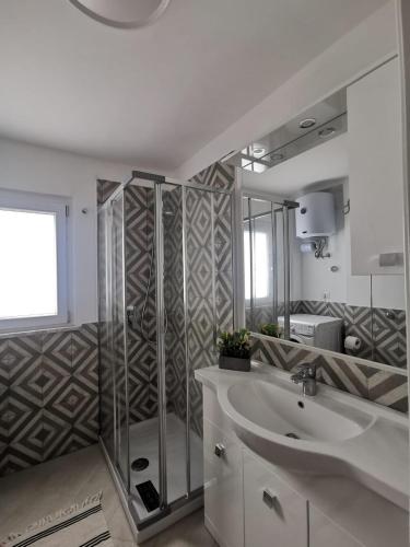 a bathroom with a shower and a sink and a mirror at SANTACROCE&S.ANTONINO HOUSE in Termini