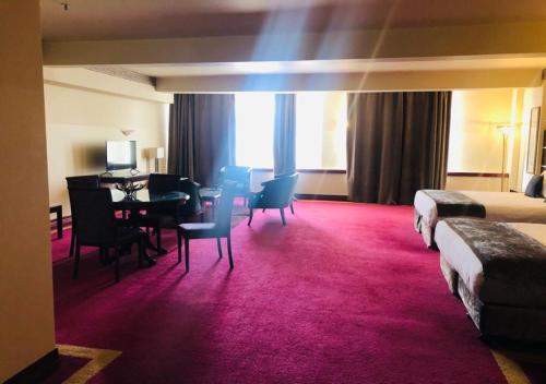 a hotel room with a bedroom with a desk and a table at VR Hamilton in Hamilton