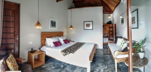 Ekas的住宿－Ombak Resort at Ekas , a luxury surf and kite surf destination，一间卧室配有一张大床和一把椅子