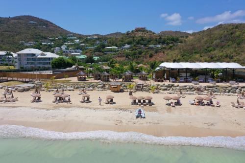 a beach with a group of people on the sand at Le Domaine Anse Marcel Beach Resort in Anse Marcel 