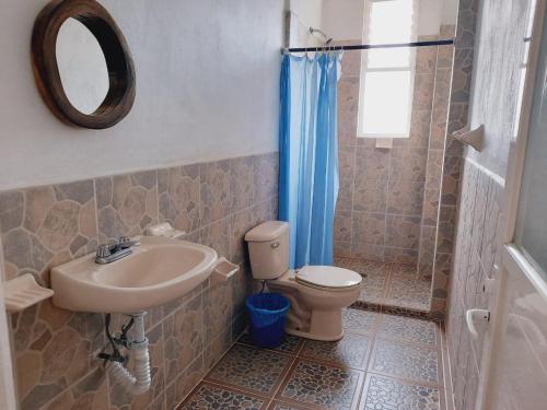 a bathroom with a toilet, sink and tub at Hotel Tiktaalik in Puerto Escondido