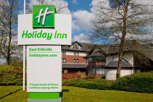 a green and white sign on a pole in front of a house at Holiday Inn Glasgow - East Kilbride, an IHG Hotel in East Kilbride