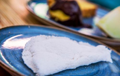 a blue plate with powdered sugar on a table with desserts at Pousada Refúgio de Maresias in Maresias