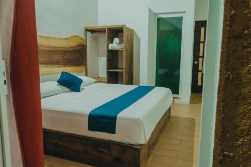 a bedroom with a bed with blue and white sheets at Casa Xalli in Santa María Tonameca
