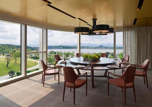 a dining room with a table and chairs and a large window at Andaz Shenzhen Bay Book 2 nights and above enjoy special offer in Shenzhen