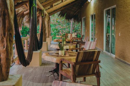 a restaurant with tables and chairs in a room at Casa Xalli in Santa María Tonameca