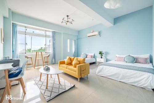 ein Schlafzimmer mit blauen Wänden und einem Bett und einem Sofa in der Unterkunft Shanzo Ansen Homestay in Taitung