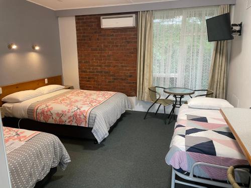 a hotel room with two beds and a television at Camperdown Cascade Motel in Camperdown