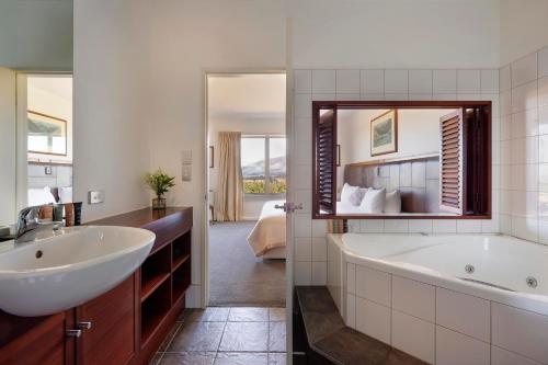 a bathroom with a tub and a sink and a mirror at Fable Terrace Downs Resort by MGallery in Windwhistle