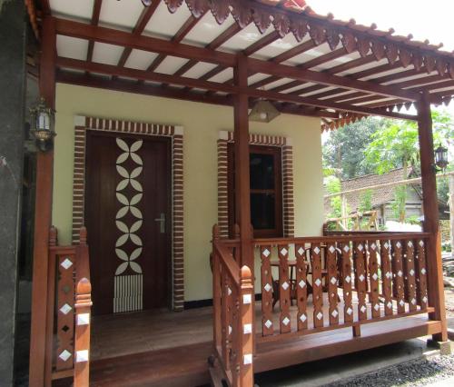 a pergola over a porch of a house at Anang Bed & Breakfast Syariah by Ndalem Beong in Magelang
