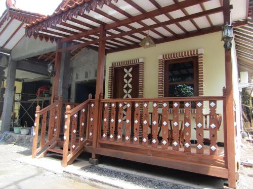a wooden deck in front of a house at Anang Bed & Breakfast Syariah by Ndalem Beong in Magelang
