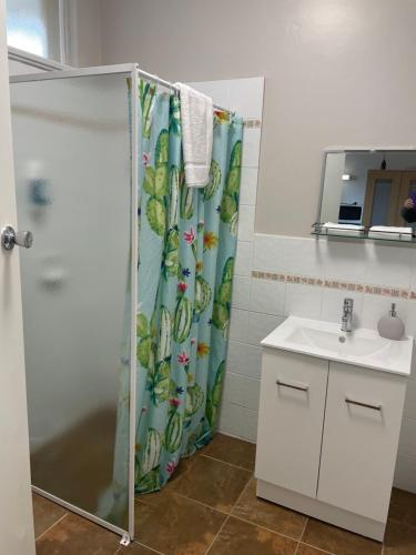 a bathroom with a shower curtain and a sink at Camperdown Cascade Motel in Camperdown