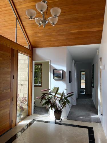 a hallway with a ceiling fan and a plant at Rose & Stream Retreat in Waikuku